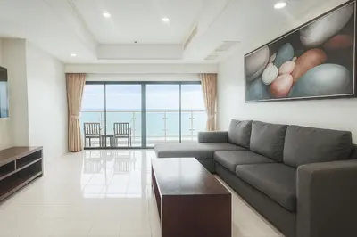 a living room with a couch and a view of the ocean at Patong Beachfront Tower 30 Floor Penthouse in Patong Beach