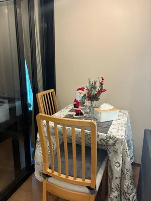a dining room table with a vase of flowers on it at Comfortable Relax at Rawai Title in Ban Saiyuan (1)