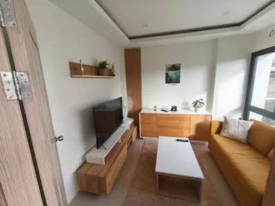 a living room with a couch and a tv at PS Guesthouse in Kathu