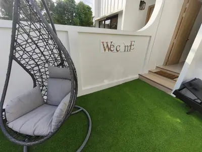 a swing chair in a room with green grass at PS Guesthouse in Kathu