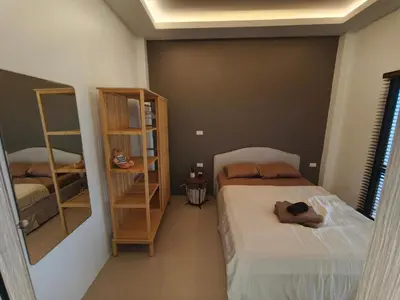 a bedroom with two beds and a book shelf at PS Guesthouse in Kathu