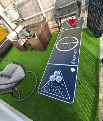 a ping pong table with a ball on top of grass at PS Guesthouse in Kathu