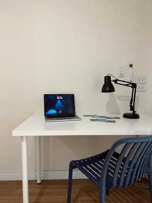 a laptop computer sitting on a white desk with a lamp at Roomy renovated Apartments in Phuket in Ban Sam Kong