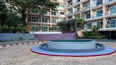 a large apartment building with a circle in front of it at Roomy renovated Apartments in Phuket in Ban Sam Kong
