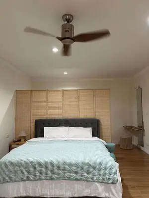 a bedroom with a bed with a ceiling fan at Roomy renovated Apartments in Phuket in Ban Sam Kong