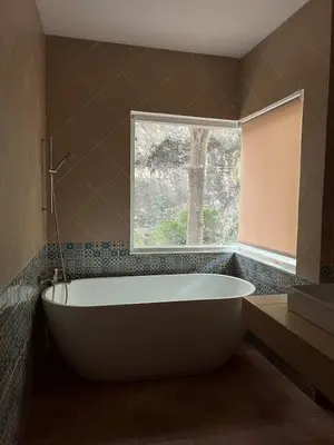 a bath tub in a bathroom with a window at Roomy renovated Apartments in Phuket in Ban Sam Kong