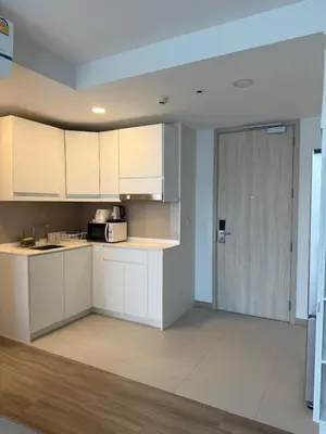 an empty kitchen with white cabinets and a door at Laguna SkyPark in Laguna Phuket