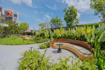 a curved bench in a park with plants at Suite Eden 1BRGarden PoolCanvas Bang Tao Beach in Laguna Phuket