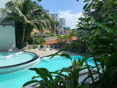 a swimming pool in a resort with palm trees at Blue Sky Penthouse @ Kamala Beach in Kamala Beach