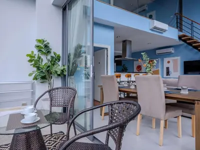 a dining room with a table and chairs at Blue Sky Penthouse @ Kamala Beach in Kamala Beach