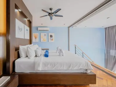 a bedroom with a white bed with a ceiling fan at Blue Sky Penthouse @ Kamala Beach in Kamala Beach