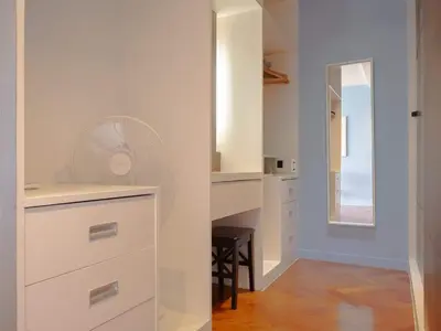 a kitchen with white cabinets and a desk with a fan at Blue Sky Penthouse @ Kamala Beach in Kamala Beach