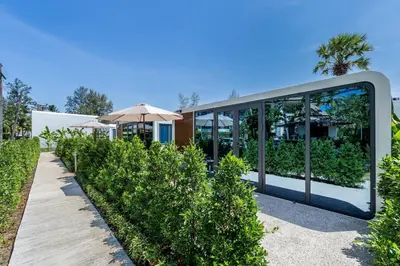 a modern house with glass walls and trees at Apple House Phuket with cozy terrace Pool & beach in Ban Lum Fuang