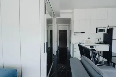 a living room with a couch and a kitchen at 3Bedrooms Mountain View at Patong Tower Phuket in Patong Beach