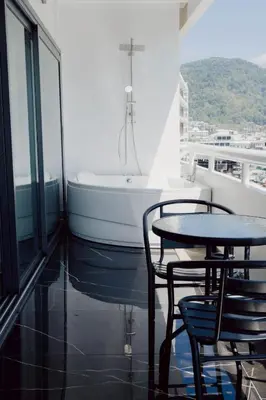 a table and chairs in a room with a bath tub at 3Bedrooms Mountain View at Patong Tower Phuket in Patong Beach