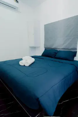 a blue bed with two towels on top of it at 3Bedrooms Mountain View at Patong Tower Phuket in Patong Beach