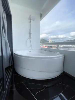 a white bath tub in a bathroom with a window at 3Bedrooms Mountain View at Patong Tower Phuket in Patong Beach