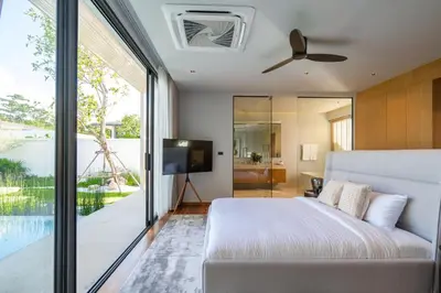 a bedroom with a bed and a sliding glass door at Villa Kaya, 3BR contemporary pool villa in Phuket