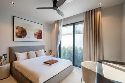 a bedroom with a bed and a large window at Villa Kaya, 3BR contemporary pool villa in Phuket