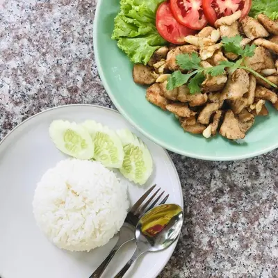 two plates of food with rice and vegetables on a table at Muchshima House in Bang Tao Beach