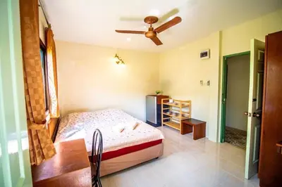 a bedroom with a bed and a ceiling fan at Muchshima House in Bang Tao Beach