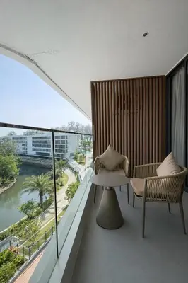 a balcony with a table and chairs and a view of a river at Beach Resort along coastline of Layan beach in Layan Beach