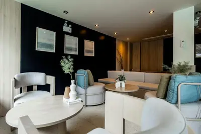 a salon with white chairs and a table and chairs at Modern apartment in the heart of Bangtao in Ban Thalat Choeng Thale