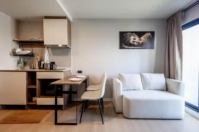 a living room with a white couch and a table at Modern apartment in the heart of Bangtao in Ban Thalat Choeng Thale