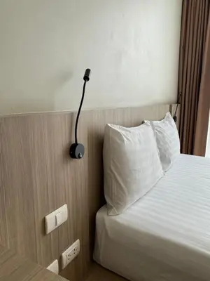 a bedroom with a bed with a lamp on it at Apartments with access to Rama IX Park in Ban Lo Long