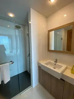a bathroom with a sink and a glass shower at Apartments with access to Rama IX Park in Ban Lo Long