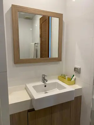 a bathroom with a white sink and a mirror at Apartments with access to Rama IX Park in Ban Lo Long