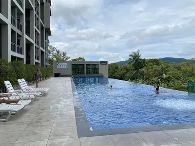 a swimming pool with lounge chairs in a hotel at Apartments with access to Rama IX Park in Ban Lo Long
