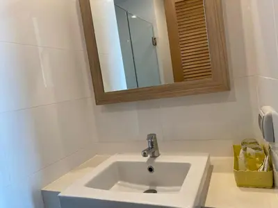 a bathroom with a white sink and a mirror at Apartments with access to Rama IX Park in Ban Lo Long