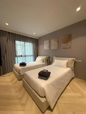 a bedroom with two beds with towels on them at Title Legendary 2 bedroom in Bang Tao Beach