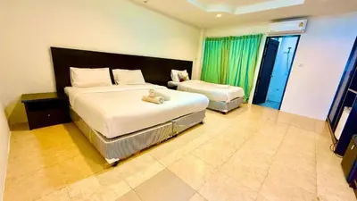 a hotel room with two beds and a television at For 3 Person in Central Pa Tong, Thailand in Patong Beach