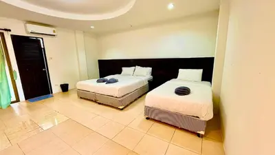 a bedroom with two beds and a tiled floor at For 3 Person in Central Pa Tong, Thailand in Patong Beach