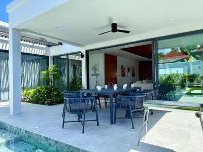 a patio with a blue table and chairs on it at Newly built private Quinta Lane 4br pool villa in Ban Saiyuan (1)