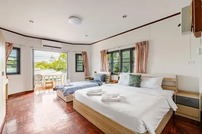 a bedroom with two beds and a living room at Villa Mayfair 4 bedrooms sea view with pool table in Ban Bang Chak