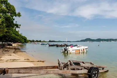 a boat sitting in the water next to a beach at Villa Mayfair 4 bedrooms sea view with pool table in Ban Bang Chak
