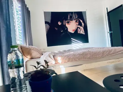 a bed in a room with a picture on the wall at HulaFling Homestay in Ban Bo Han