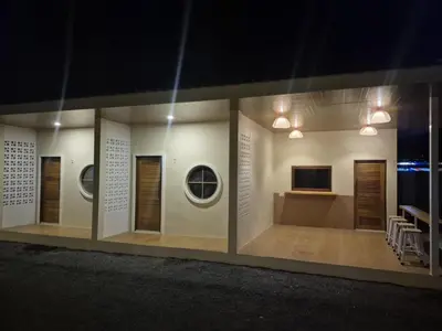 a room with a wall with windows and a television at Cozy Stay Koh Yao Yai in Ko Yao Yai