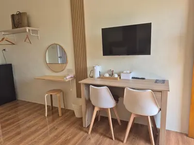 a hotel room with a desk and two white chairs at Cozy Stay Koh Yao Yai in Ko Yao Yai
