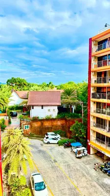 a parking lot with cars parked in front of a building at Bright Sun Apartment with Pools in Rawai Beach
