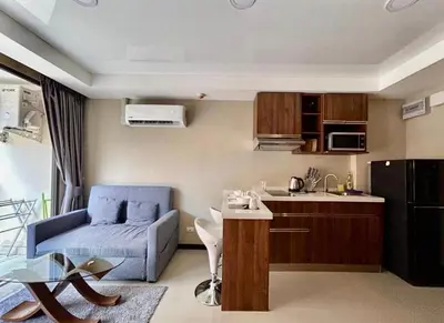 a living room with a blue couch and a kitchen at Bright Sun Apartment with Pools in Rawai Beach