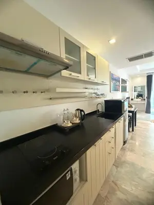 a large kitchen with a black counter top at Phuket Rawai beachfront by Tris in Nai Harn Beach