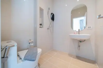 a white bathroom with a toilet and a sink at Espuma Patong pool villa in Patong Beach