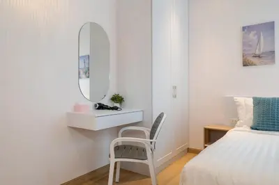a bedroom with a mirror and a chair next to a bed at Espuma Patong pool villa in Patong Beach