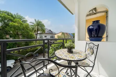 a table and chairs on a balcony with a vase at Suite dream villa Bangla Patong sleep 8 in Patong Beach