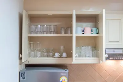 a kitchen cabinet filled with glasses and mugs at Suite dream villa Bangla Patong sleep 8 in Patong Beach