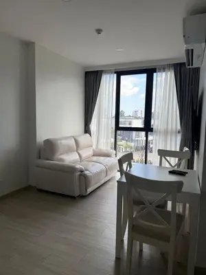 a living room with a white couch and a table at Sky Park Family Comfort in Laguna Phuket